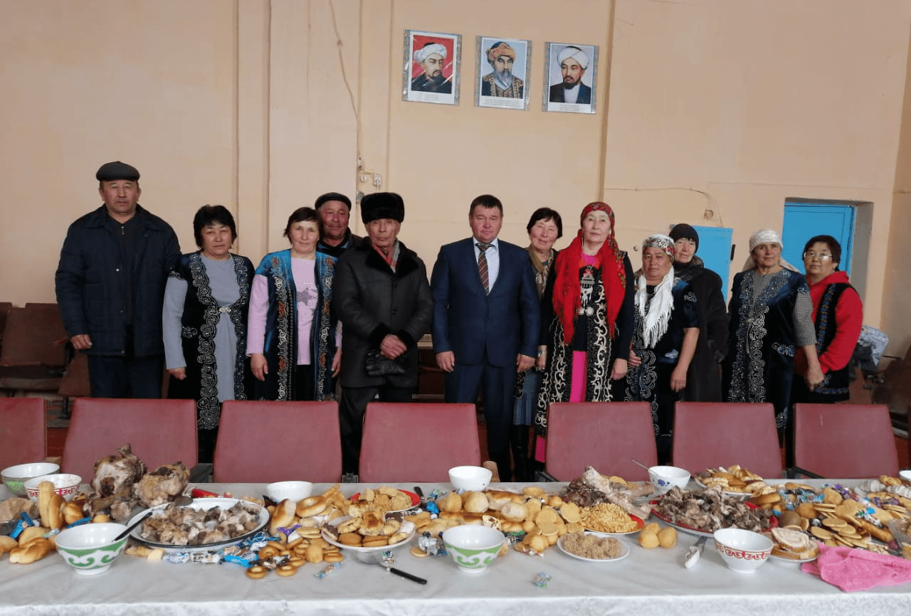 A group of people standing in front of a table full of food